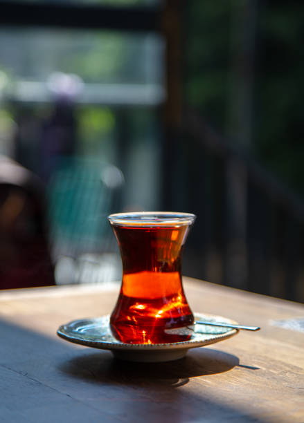 Glass of hot tea is standing on the cafe table.