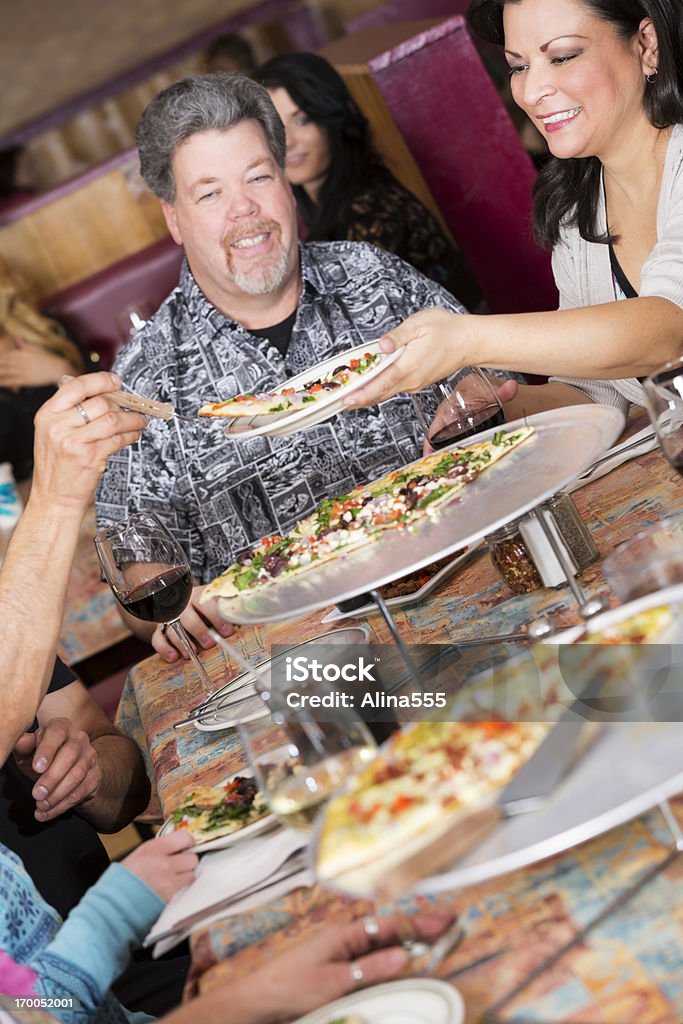 Heureux groupe d'amis partage une pizza au restaurant - Photo de Adulte libre de droits