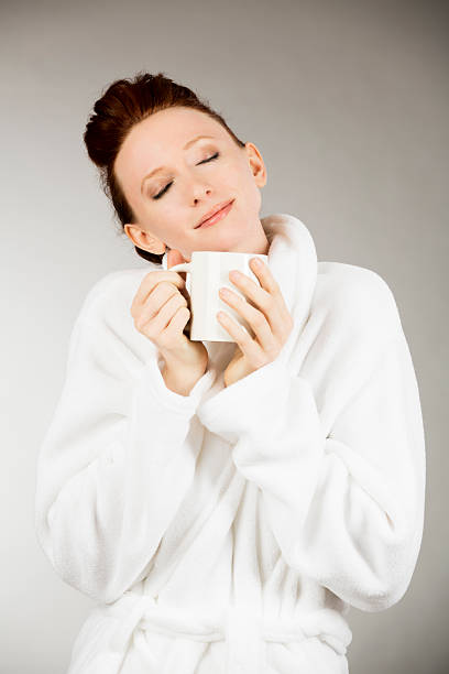 istock Young beautiful woman enjoying hot coffee on gray background 170052069
