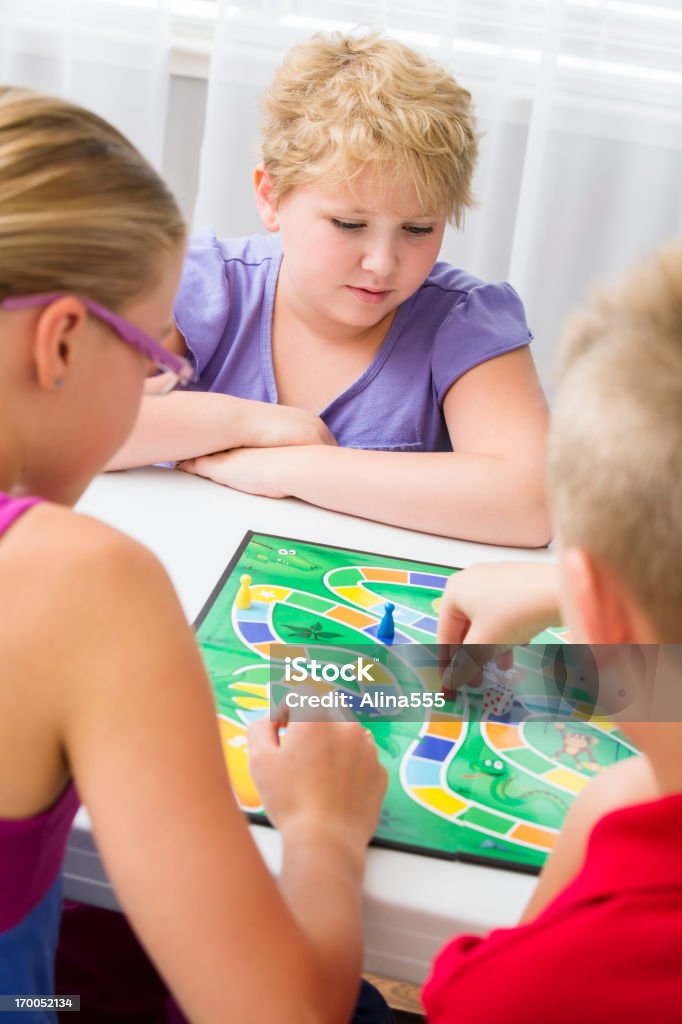 Gruppo di bambini che giocano il gioco da tavolo - Foto stock royalty-free di Famiglia