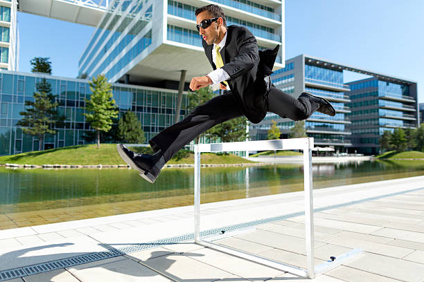 istock business man over hurdle near offices 170052290