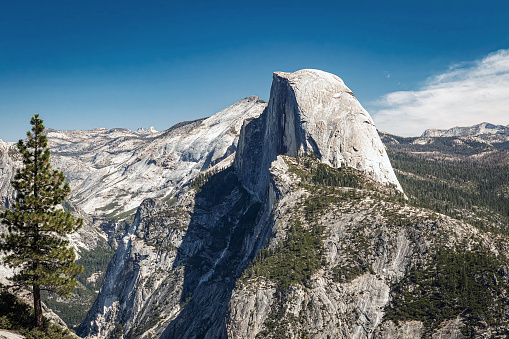 Gray granite formation of Half Dome and the surrounding landscape of Yosemite National Park California