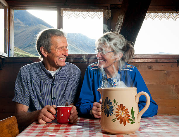felice coppia senior bere caffè in fattoria - mountain cabin european alps switzerland foto e immagini stock