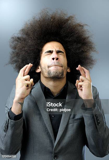 Man With Big Hair Keeping Fingers Crossed Stock Photo - Download Image Now - Fingers Crossed, Men, Adult