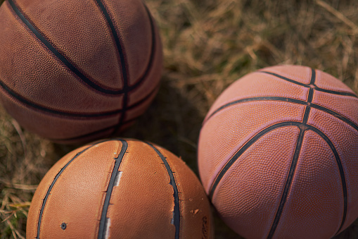 Worn basketballs at a pickup basketball at the park.
