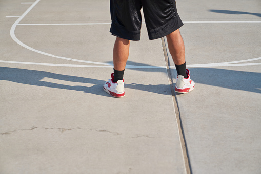 A basketball player ready for play during a pickup basketball game at the park