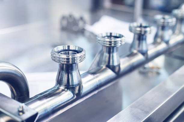 istock Separation pipe made of stainless steel with threaded elbows in production. Metal structures for production lines. Toned image 1700554888