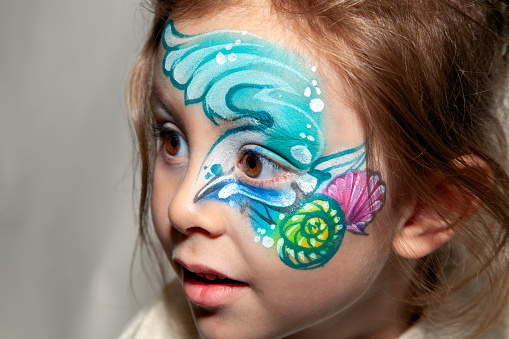 Young hazel eye girl with a painted face.