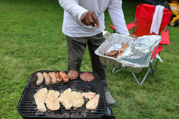 istock A black man grilling meat on a charcoal grill in a backyard 1700562228