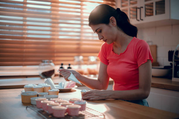 istock Asian Young Female Creating Decoration Cake in Her Kitchen 1700572015