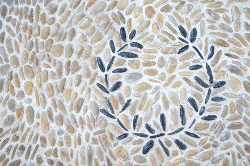 Dark stones are set into laurel wreath pattern in lighter stone background