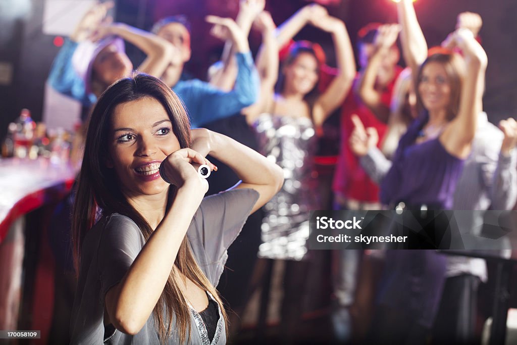 Bela brunette cantar com o microfone em um clube. - Royalty-free Bar - Local de entretenimento Foto de stock