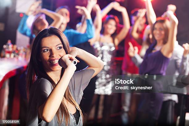 Bela Brunette Cantar Com O Microfone Em Um Clube - Fotografias de stock e mais imagens de Bar - Local de entretenimento - Bar - Local de entretenimento, Karaoke, Cantar