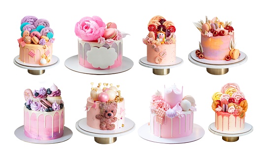 Various pink cakes isolated on white background. Cakes with teddy bear, edible flowers, unicorn, marshmallow, meringues and macarons