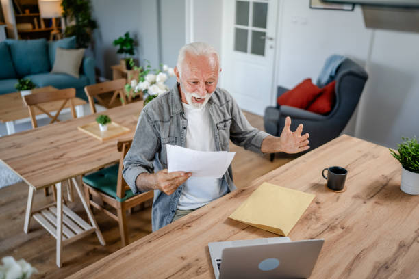 istock senior caucasian man open mail letter or document envelope at home 1700621918