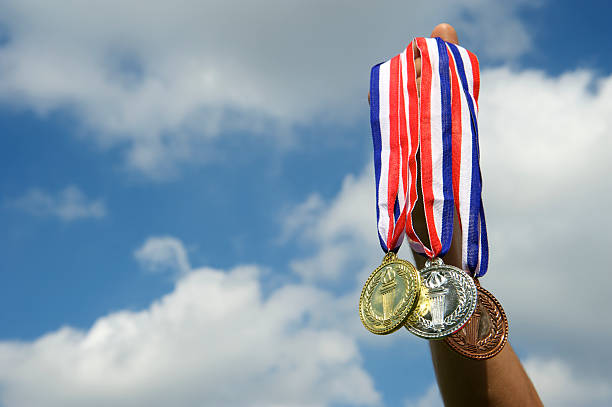 istock Hand Holds Up Gold Silver Bronze Medals in Sky 170062246