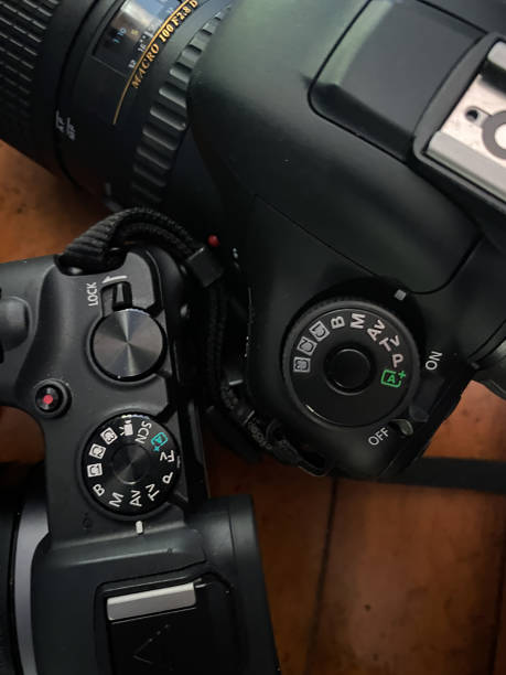 istock Two digital cameras viewed from above in vertical frame on wooden table 1700623079