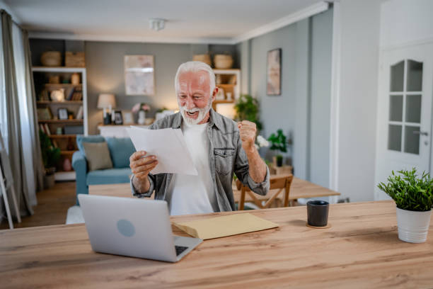istock senior caucasian man open mail letter or document envelope at home 1700623101
