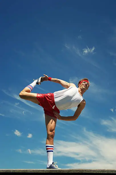 Photo of Nerd Athlete Stretches Against Blue Sky