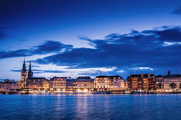 The Alster promenade with the town hall in Hamburg at dusk.