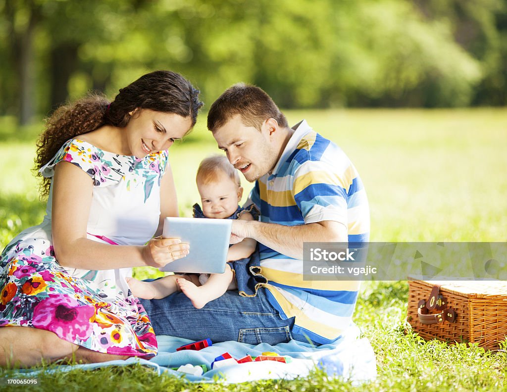 Rodziny za pomocą cyfrowego tabletu na zewnątrz. - Zbiór zdjęć royalty-free (25-29 lat)