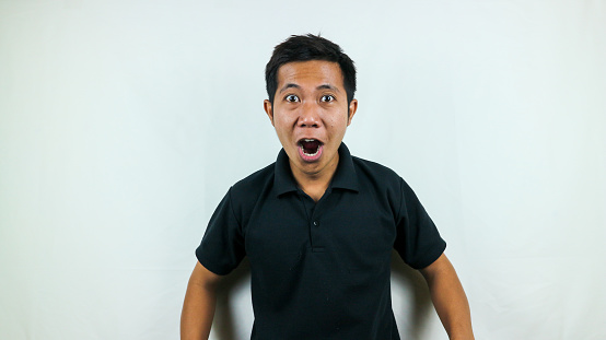 Wow face of Asian man shocked what he saw on isolated white background.