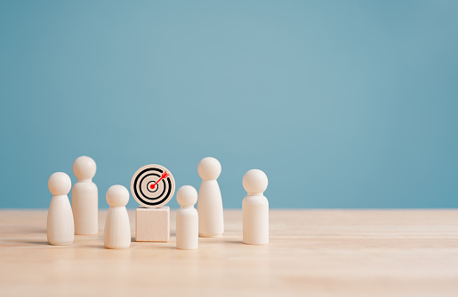 Business target goal and marketing strategies setting concept for achievement, Wooden figures standing with dartboard and arrow for goals. Company plan objective purpose and future business success.