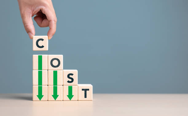 istock Lean or Cost reduction concept. Optimize manufacturing management. Decreasing company expense to maximize profits. Hand puts wooden cube with words cost and green down arrows. Business improvement. 1700692161
