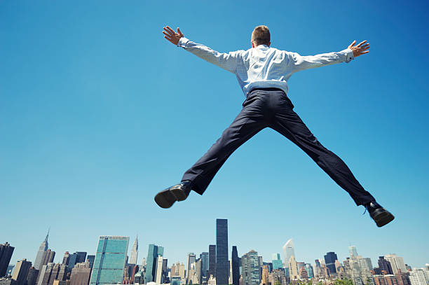 istock Businessman Does Big Leap Above City Skyline 170070332