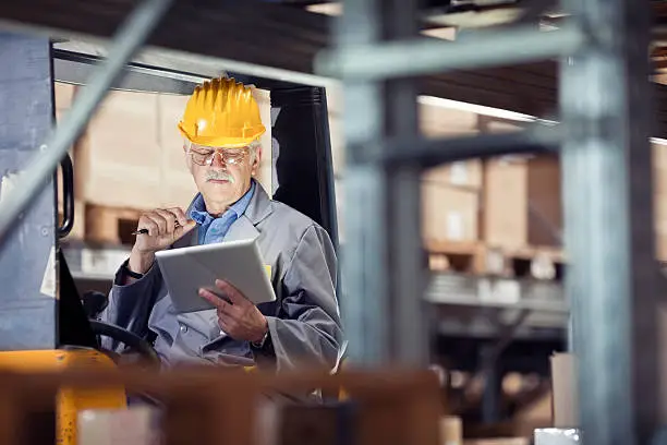 Photo of Forklift operator looking at a digital tablet