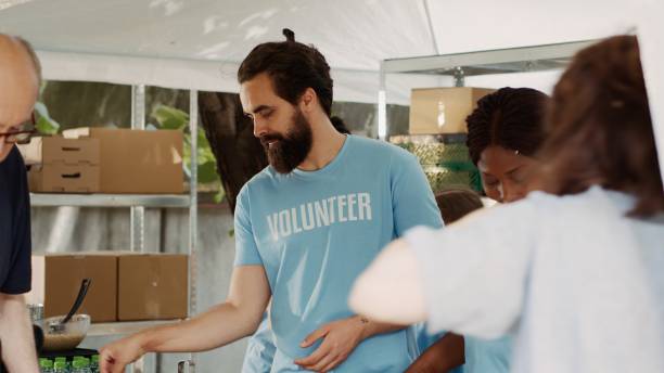 istock Female Volunteer Assists Elderly Man 1700715019