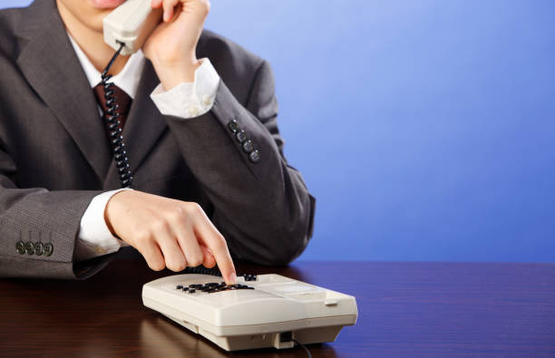 istock Businessman is dialing telephone number with handset in hand 1700716189