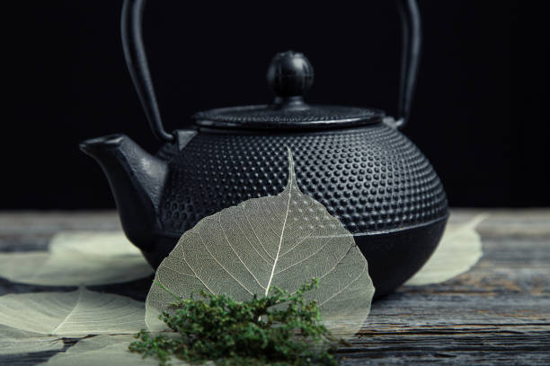 나뭇잎 해골로 만든 장식이 있는 검은색 철제 테츠빈 찻주전자 - tetsubin teapot 뉴스 사진 이미지