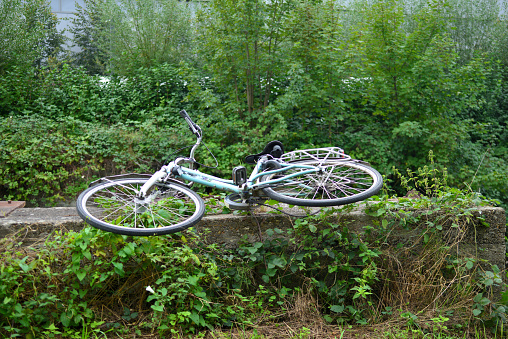 Leuven, Vlaams-Brabant, Belgium - September 17, 2023: stolen and abandoned woman's bicycle along a riverbed on a remote road