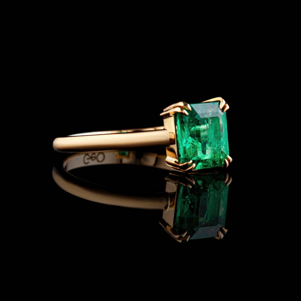 istock beautiful yellow gold ring with emerald on a black background 1700721243