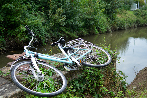 Leuven, Vlaams-Brabant, Belgium - September 17, 2023: stolen and abandoned woman's bicycle along a riverbed on a remote road