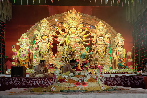 Howrah, West Bengal, India - 5th October, 2022 : Vog,decorated Holy food being offered to Goddess Durga, Hindu purohits arranging for puja in background.Durga Puja ritual.Biggest festival of Hinduism.