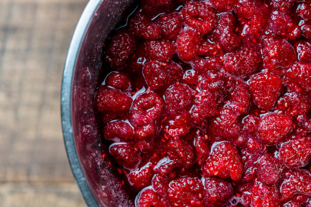 istock Fresh red raspberry berry, covered with granulated sugar for jam preparation in bowl, top view, closeup. Background and texture of raspberries with sugar 1700781543