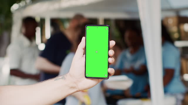 Person Holds Cellphone With Green Screen