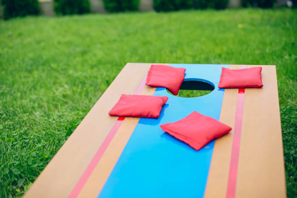 istock Red beanbags sitting on blue cornhole board platform 1700810622