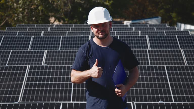 A solar panel maintenance technician checks the operation and efficiency of photovoltaic solar panels on a rooftop. Solar clean green energy