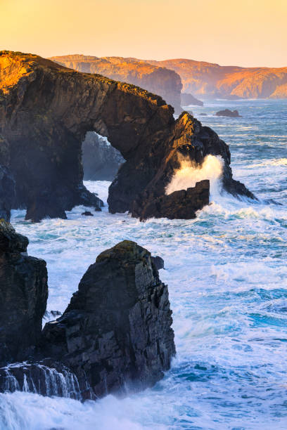 First light catching the Stac a' Phris, a natural sea arch, on a windy day on the Isle of Lewis, Outer Hebrides, Scotland.