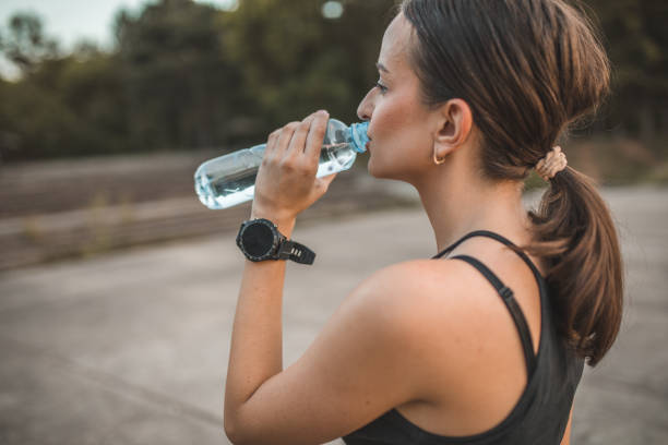 istock Athlete woman drinks water from a plastic bottle 1700839297