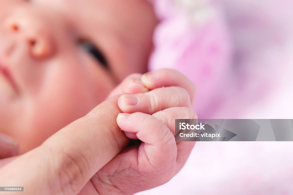 Newborn baby girl holding madres mano - Foto de stock de Niñas bebés libre de derechos