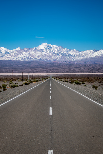 Beautiful mountainous landscape in Mendoza, Argentina. Road to the mountain. Road in the middle of the desert. Road surrounded by beautiful mountains.