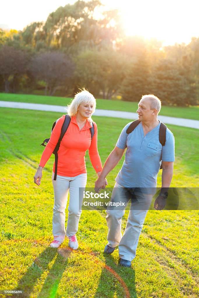 Pie feliz pareja sosteniendo las manos al aire libre - Foto de stock de 50-59 años libre de derechos