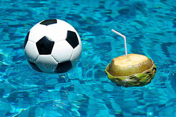 bola de futebol com piscina flutuante de coco brasileiro - ball floating on water coconut straw - fotografias e filmes do acervo
