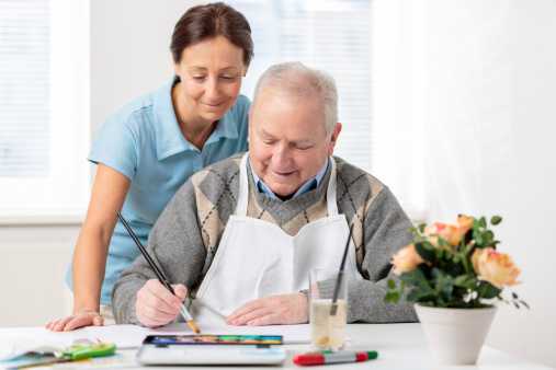 Nursing home: Senior man painting with water colors