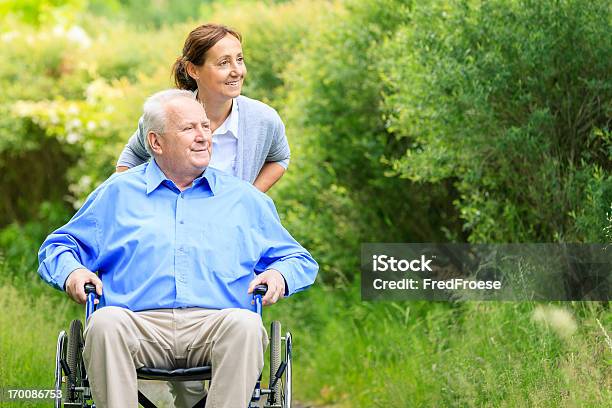 Старший Человек Сидя На Инвалидной Коляске С Лицом Осуществляющим Уход — стоковые фотографии и другие картинки Пожилой возраст