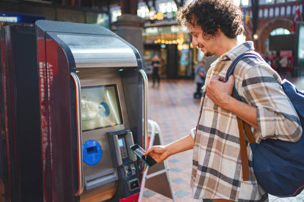 istock Men buying train tickets at the train station 1700890335